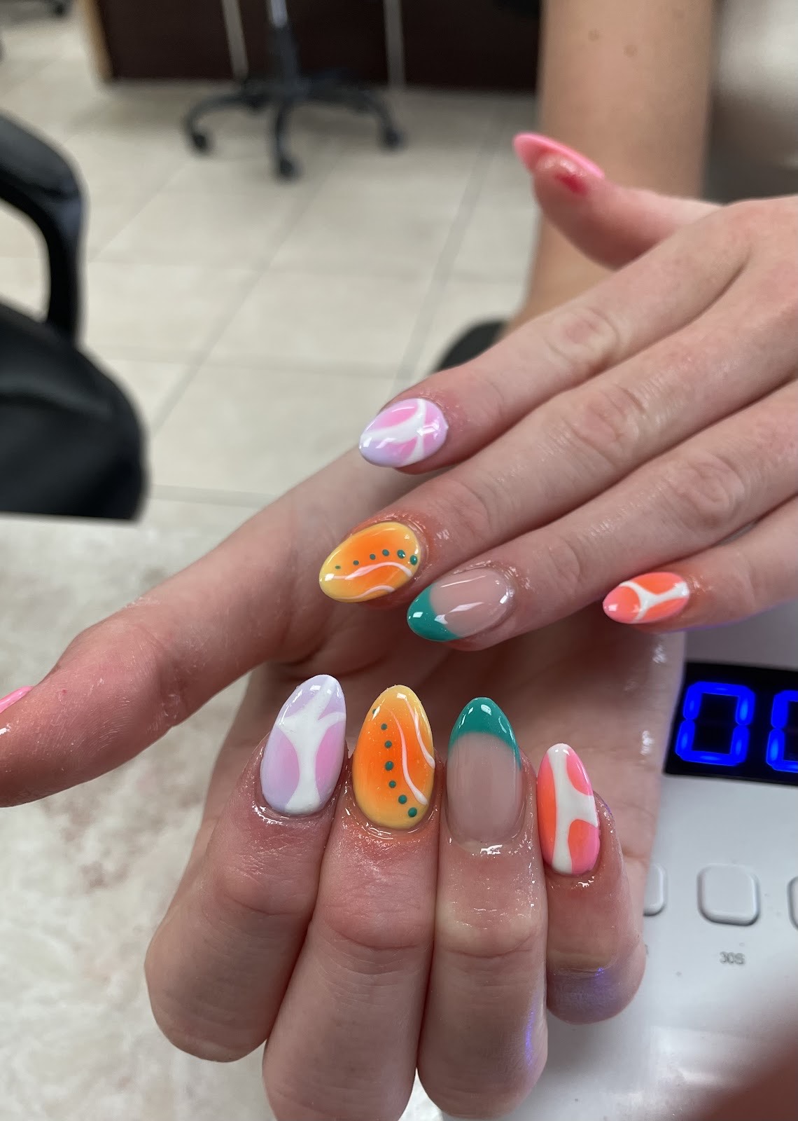 Bright multicolor almond nails with abstract swirls, orange and teal French tips at Twinkle Nails & Spa