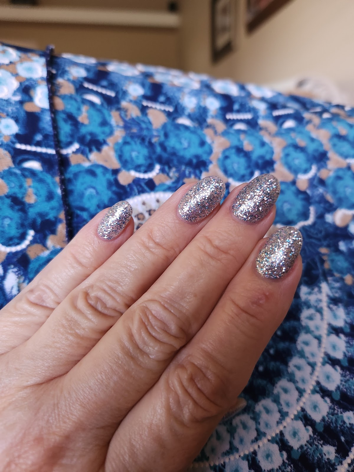 Silver glitter almond nails sparkling in the light