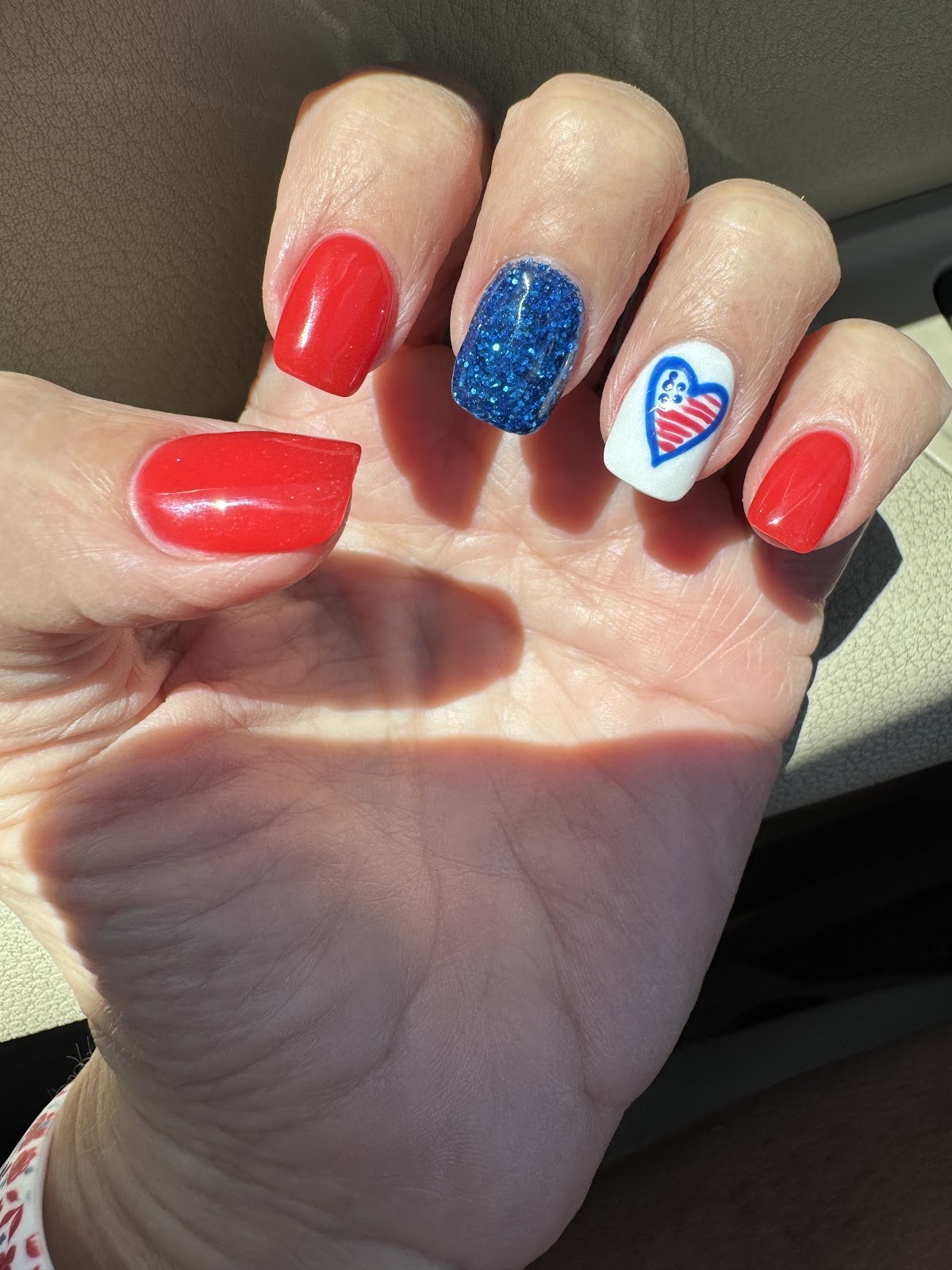 Patriotic red, white and blue nails with glitter and heart-flag accent